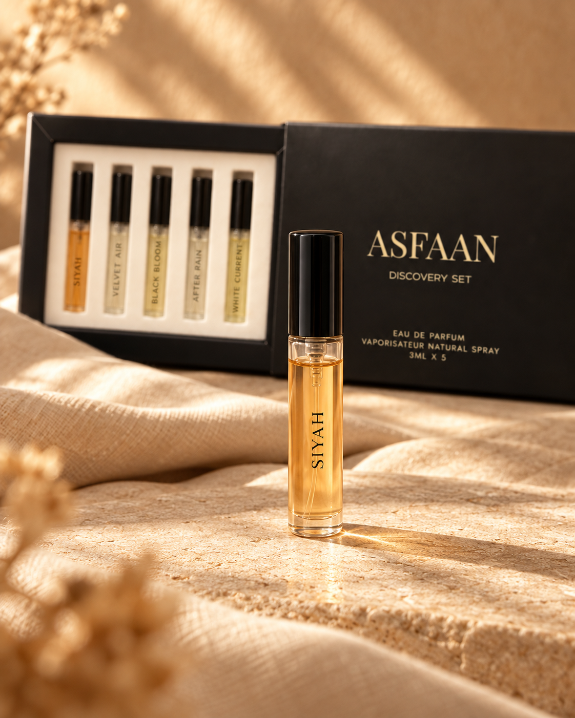 ASFAAN Siyah 3 ml sample vial in the foreground with the five fragrance sliding discovery set behind